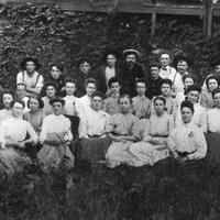 Group of female and male workers posing outside for group photo