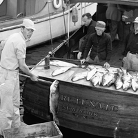 Carl Darenberg, Sr., the donor of this collection, stands in front of his boat, Foretenate.