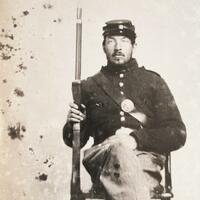 Soldier seated with rifle