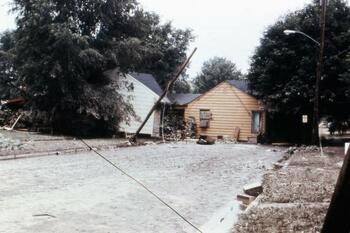 A house, moved by flood waters, sits in the middle of a street