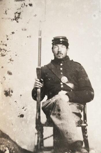 Soldier seated with rifle