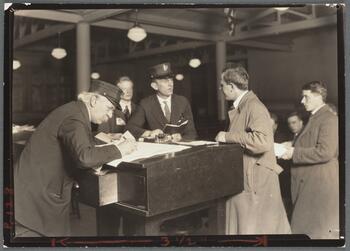 Interpreter and recorder interviewing newcomers, Ellis Island, New York, 1908