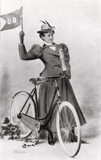 Image of a woman on a bicycle waving a flag